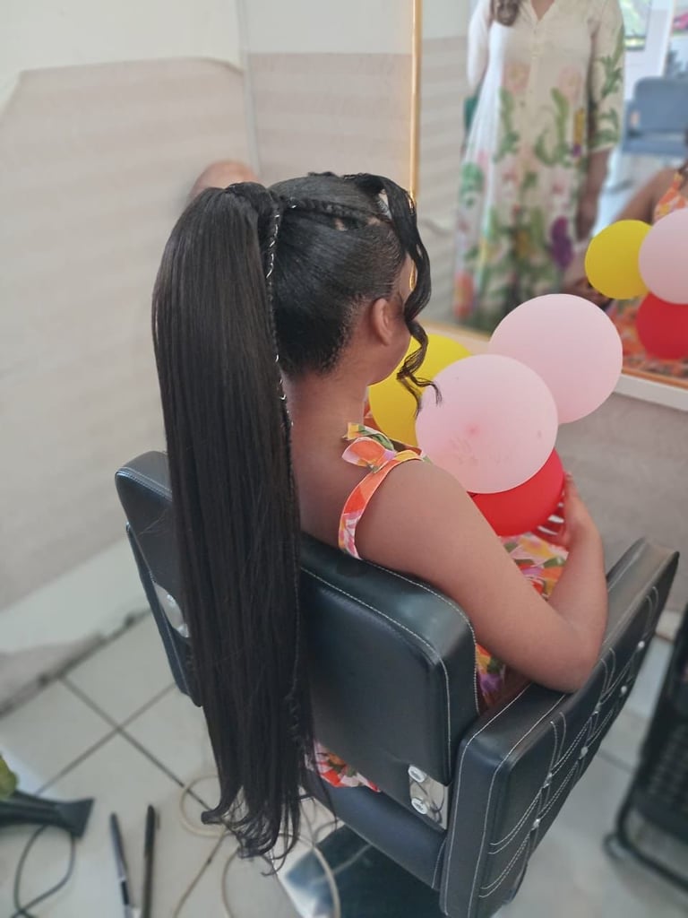 Woman with long black hair and braids holding a child